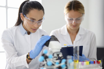 Two researchers in laboratory are doing research. Design research work in chemistry and medicine concept