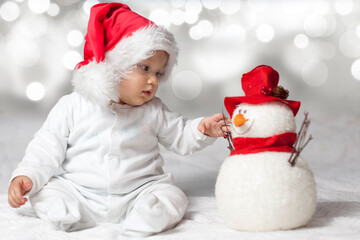 Baby with red santa hat and snowman