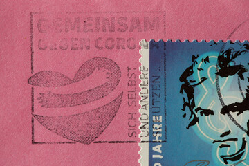 Deutsche Briefmarke mit Posstempel gemeinsam gegen Corona auf einem Briefumschalg