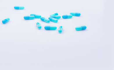 Selective focus on blue capsule pill on white background. Pharmaceutical industry. Pharmacy products. Healthcare and medicine. Blue capsule pills with beautiful patterns. Pharmaceutical manufacturing.