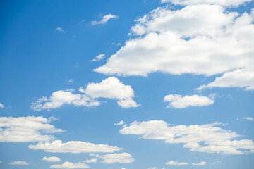 Naklejka na ściany i meble Blue sky background with white fluffy clouds in the fresh sunny day.