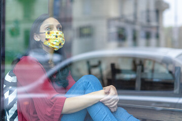 sad Indian woman locked in the house during lockdown, portrait of young girl in quarantine seen...