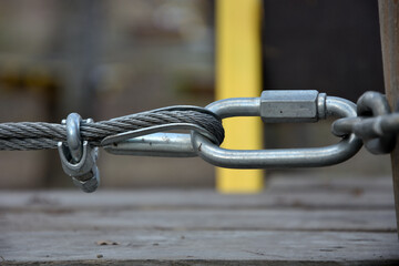 The metal cable is attached to the metal chain by a special attachment .