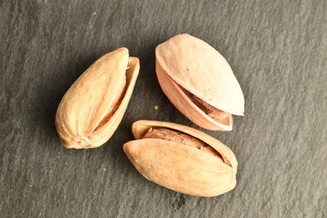 Organic salted pistachios, close-up, on a slate board.