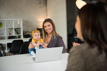 Single mother holding her baby girl on a job interview