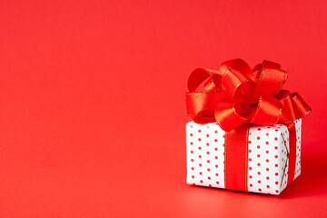 Festive gift with a ribbon on a red background with a place for your text. concept for new year,...