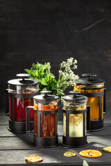 set of Tea in the French press sea buckthorn, apple, strawberry and ginger on the table on black background