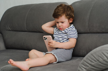 Cute little boy looking at camera, funny child at home