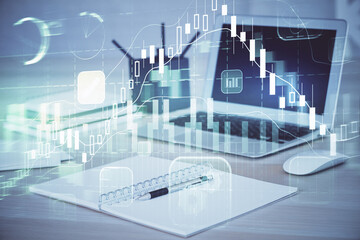 Fototapeta premium Stock market graph on background with desk and personal computer. Multi exposure. Concept of financial analysis.