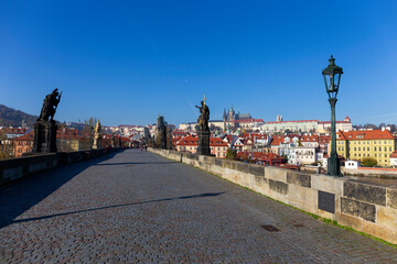 Obraz premium Autumn colorful Prague Lesser Town with gothic Castle from Charles Bridge with its baroque Sculpture, Czech Republic