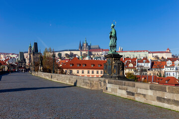 Obraz premium Autumn colorful Prague Lesser Town with gothic Castle from Charles Bridge with its baroque Sculpture, Czech Republic