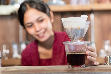 portrait of young woman making drink with tea strainer