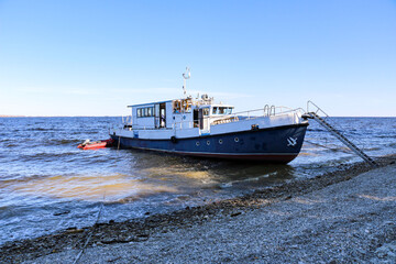 Fototapeta premium industrial merchant seagoing vessel sails on small waves in pre-storm weather. ship with cargo goes to point of delivery of goods.