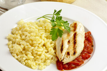 escalope de poulet grillée à la sauce tomate et pâtes dans une assiette