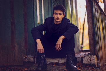 Portrait with a handsome young man in autumn forest, fashion concept.