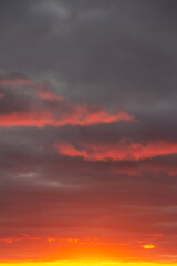 Wonderful November sunset with bright red-pink clouds on a dark gray-blue sky