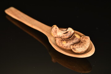 Fragrant roasted cashews, close-up, on a black background.