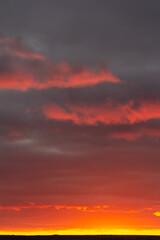 Wonderful November sunset with bright red-pink clouds on a dark gray-blue sky