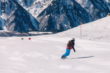 Fototapeta na wymiar People ski and snowboard at a beautiful resort in the mountains of Georgia