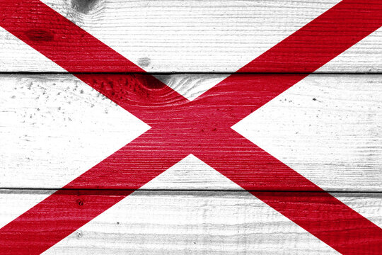 Alabama flag painted on old wood plank background. Brushed natural light knotted wooden board texture. Wooden texture background flag of Alabama