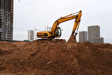 Excavator during earthmoving at construction site. Backhoe dig ground for the construction of...