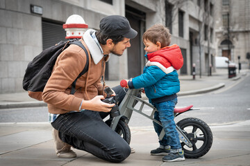 2 years old toddler with his father in the middle of the street