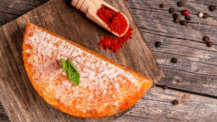 Cheese piece of Spanish manchego cheese made from cow milk with red paprika close up. cheese farmer. The concept of natural eco dairy products, Long banner format, top view