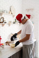 Chef in santa hat cooking a dessert in the kitchen wipping cream