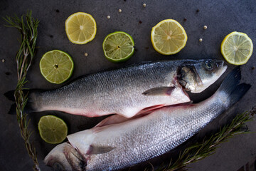 Fresh ingredients top view photo. Trout fish with potatoes, lemon slices and rosemary on gray table. 