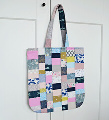 Colorful quilted patchwork tote bag and white wardrobe with black knobs