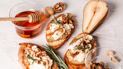Appetizers table with italian antipasti snack. Pear and brie crostini with honey, pecan and rosemary
