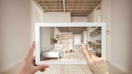 Augmented reality concept. Hand holding tablet with AR application used to simulate furniture and design products in empty interior with ceramic tiles. Kitchen, living room, sofa