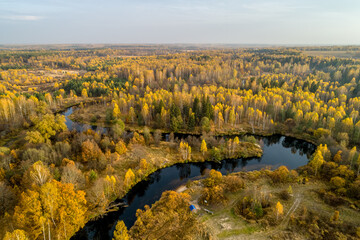 Golden autumn, view from a drone, river bend, morning fog. Sunny morning