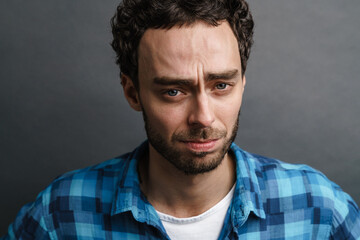 Obraz premium Unshaven unhappy guy posing and looking at camera