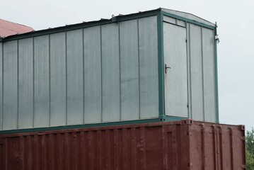 Fototapeta premium one large gray metal container with a door stands on the street against the background of the sky
