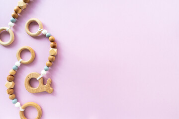 Eco-friendly wooden children's toys on a pink background, top view, flat layout, copy space. Flat composition, baby background