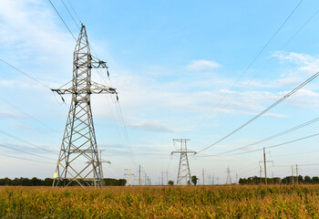High voltage power lines on blue sky background. Electric transmission pylon tower. Wire electrical...