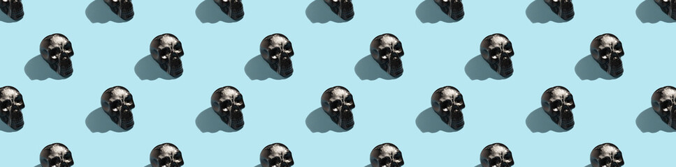 Black human skull with wax and hard shadows on a blue background, seamless pattern. Background for design, Halloween.