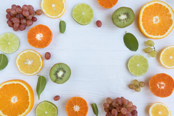 Citrus fruits and kiwi cut into circles, grapes on a white background with space for text. Poster, banner, article.