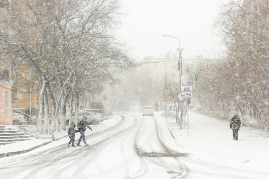 Blizzard, mist and snowfall in city, cars on sleet road, poor visibility, winter bad weather