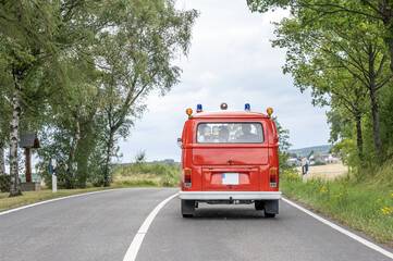 T1 fire engine red firefigther car Oldtimer classic car drivin on the Road - obrazy, fototapety, plakaty