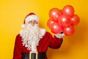 Santa Claus holding bunch of red balloons