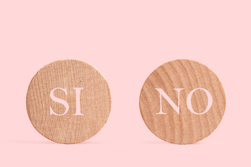 Dos círculos de madera con palabras escrita Si y No sobre un fondo rosa liso y aislado. Vista de frente. Copy space - obrazy, fototapety, plakaty