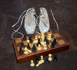 Ballet Slippers and Old Chessboard and Figurines, in a dark tone. © Salavat Safiullin