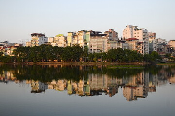 Public city park near Tay lake in the downtown district of Hanoi, Vietnam. Residential houses reflected in water