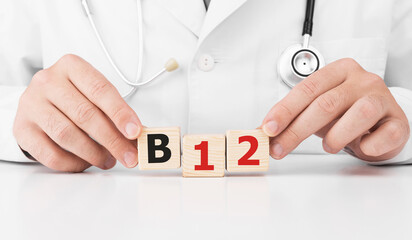 Doctor holds wooden cubes in his hands with text B12