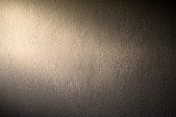 The cement empty wall has a light on the left for background or writing text.