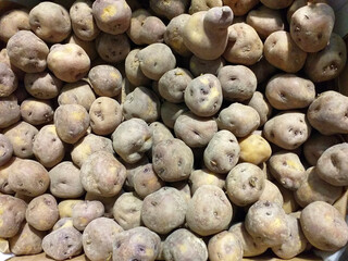 Aerial view of organic potatoes in bulk. Raw Sweet potato pile display at fresh market stall....