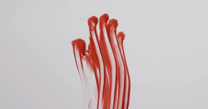 Female bloody hand sliding down on white background.