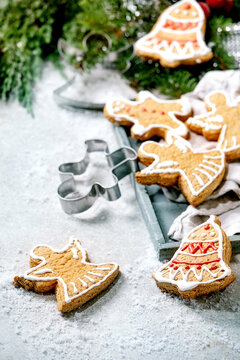 Homemade traditional Christmas gingerbread cookies with icing ornate. Gingerbread Man, angel, bell with xmas decorations over white bokeh background.